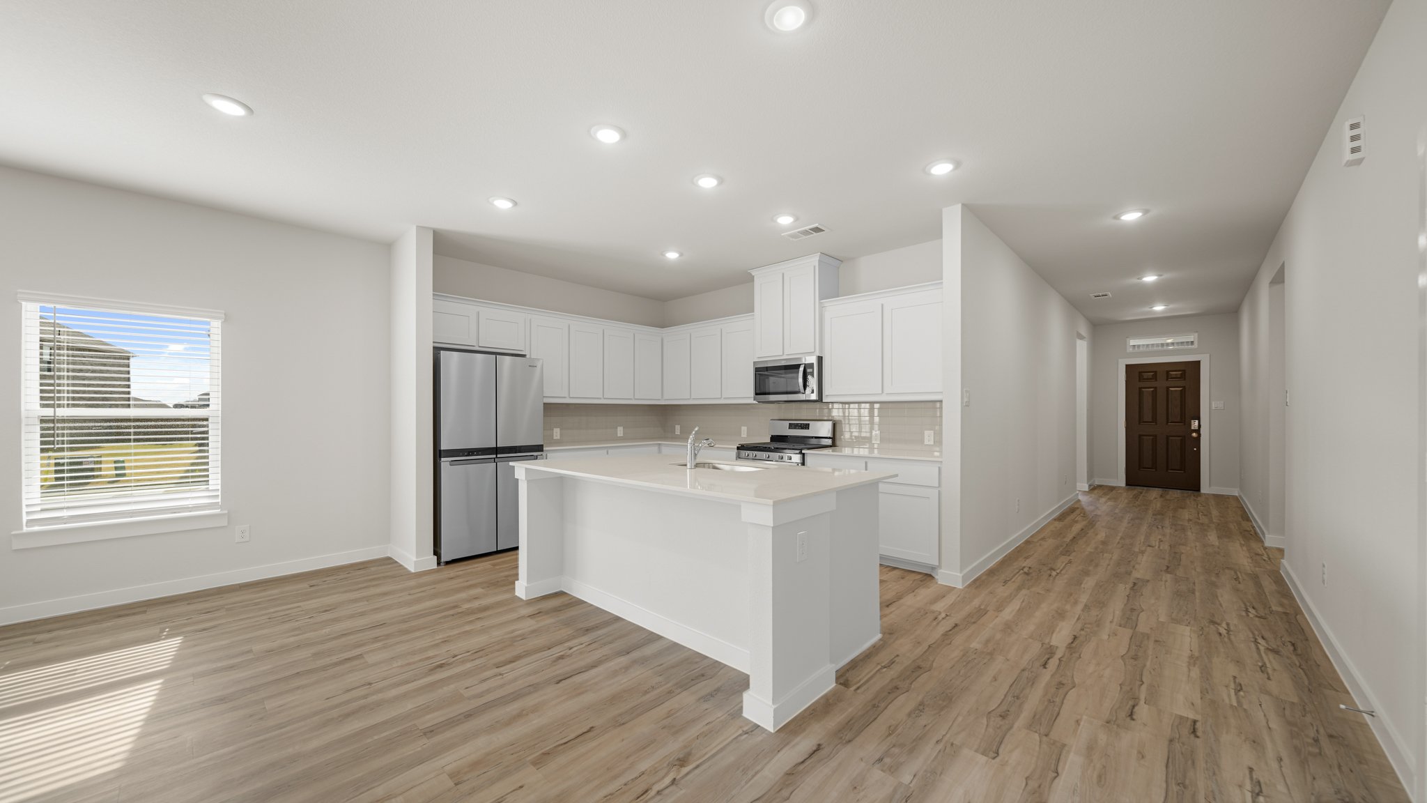 A kitchen with white cabinets.