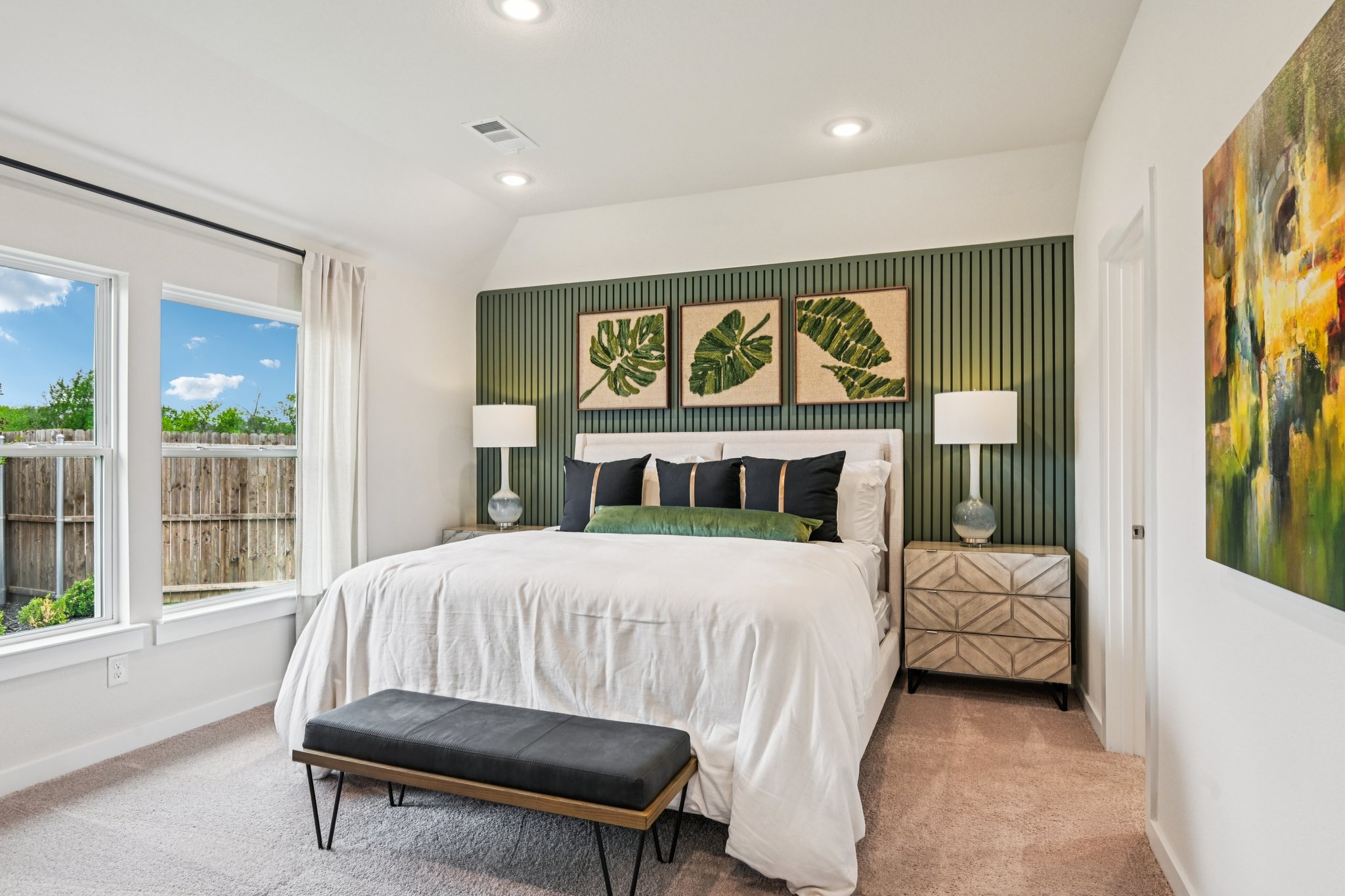 A bedroom with a bed and a bench.