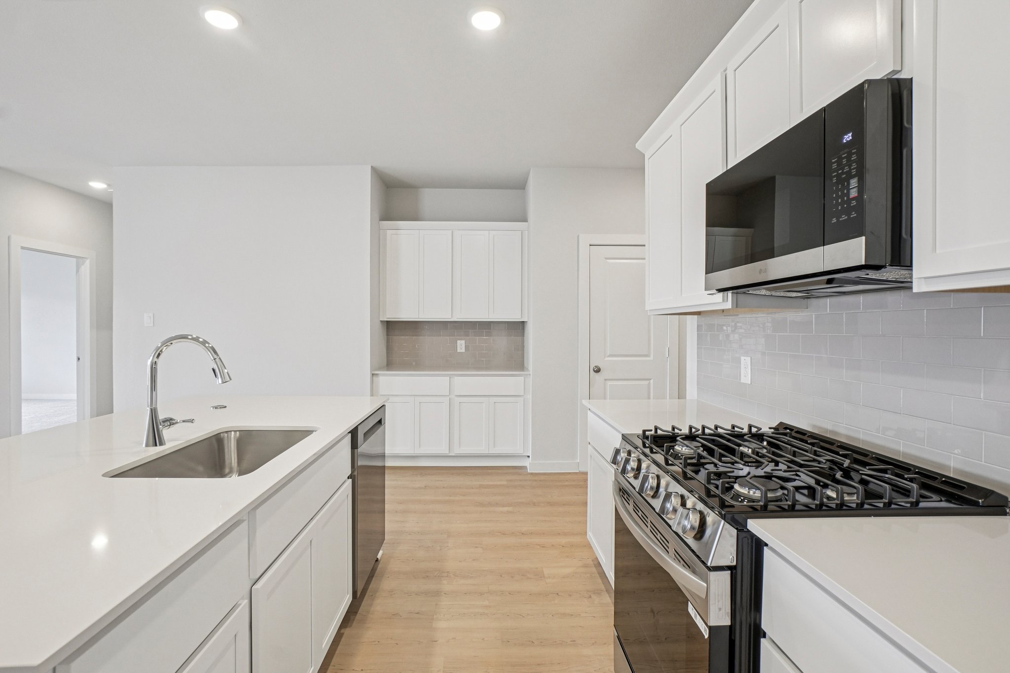 A kitchen with white cabinets.