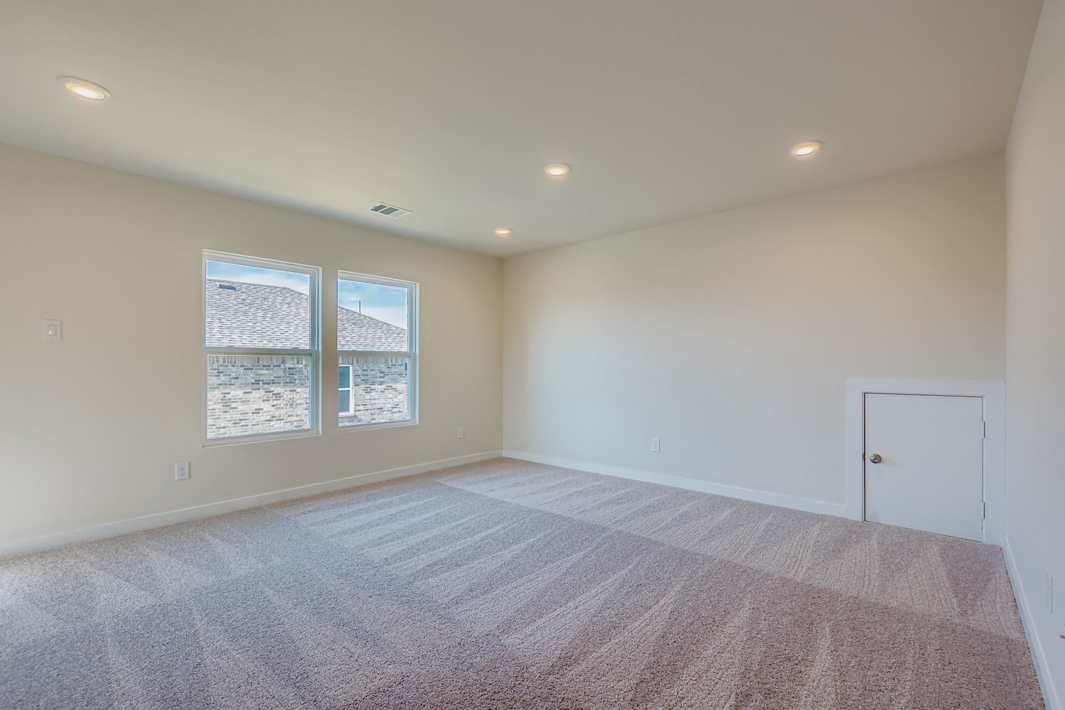 A room with a carpet and windows.