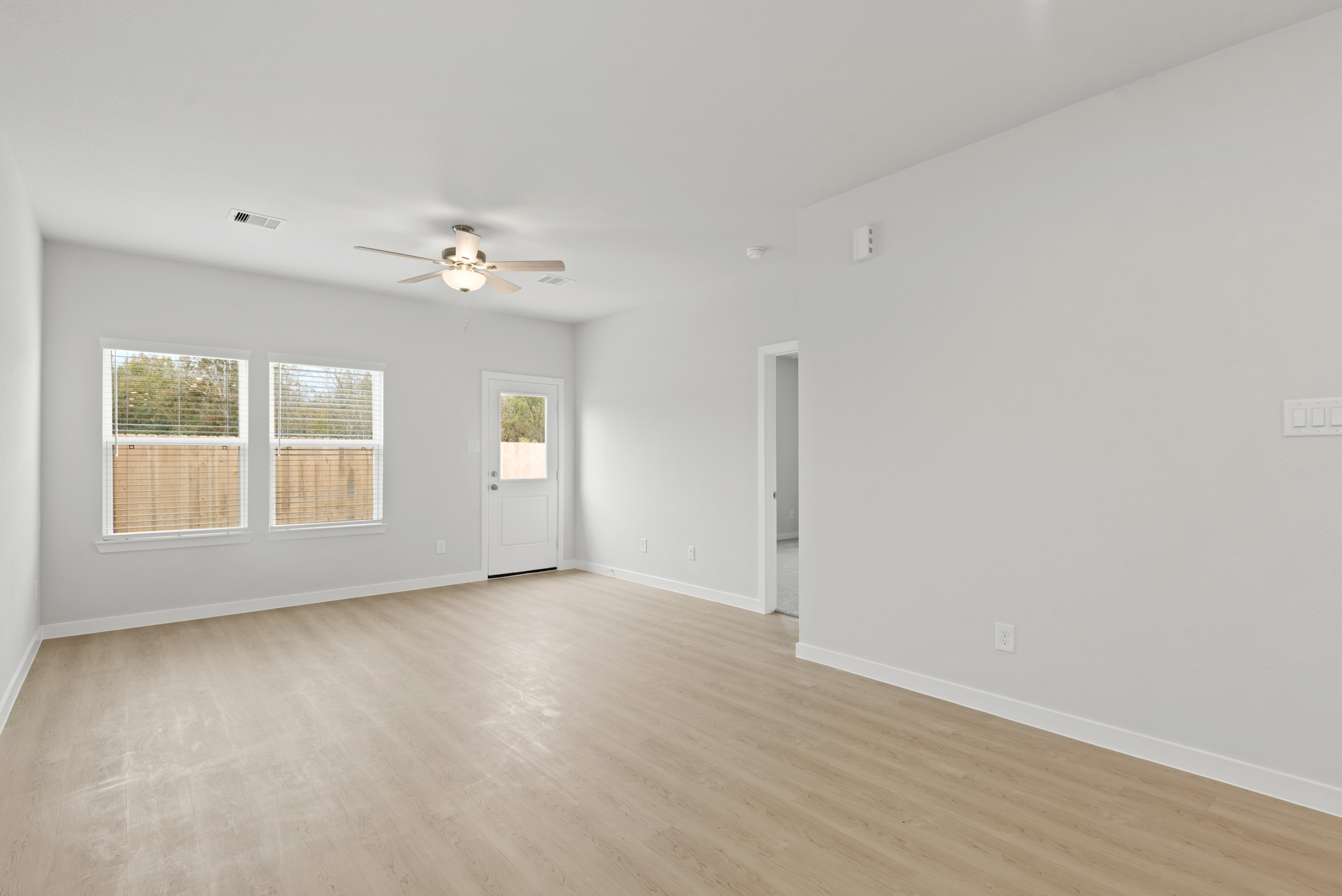 A room with a wood floor and a ceiling fan.