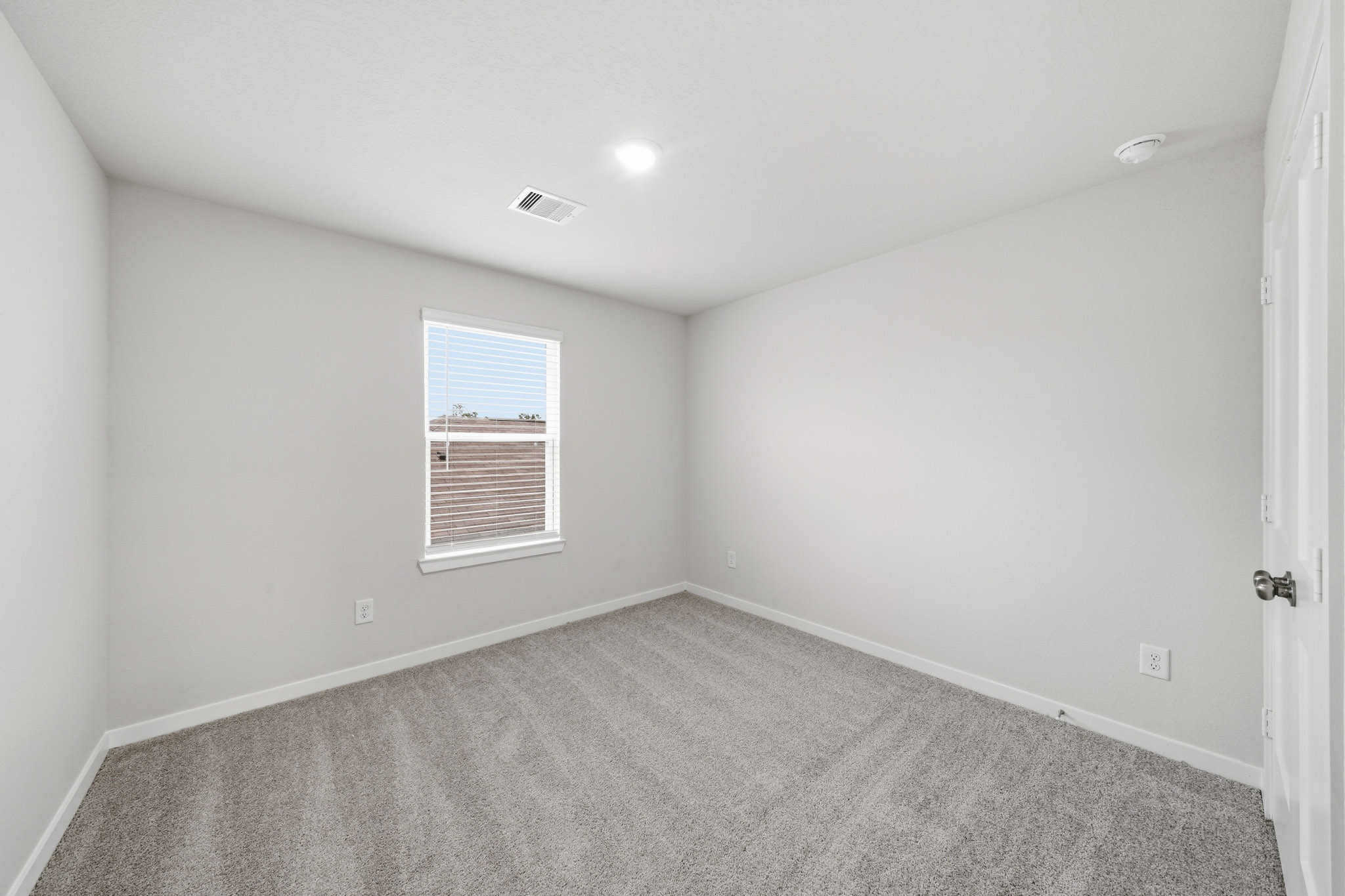 A room with a carpet and a window.