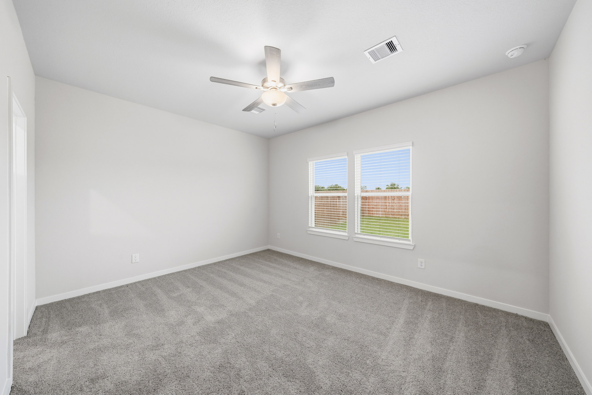 A room with a ceiling fan and a window.