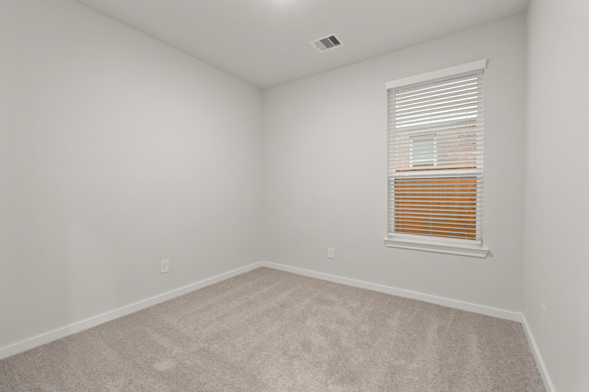 A room with a window and carpet.