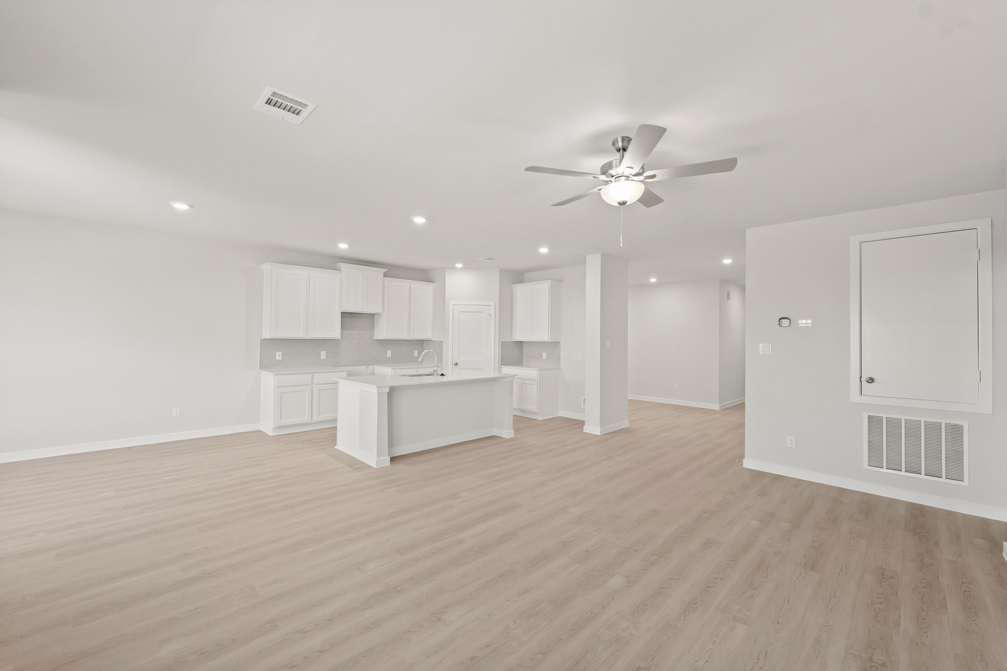 A room with white cabinets and a ceiling fan.