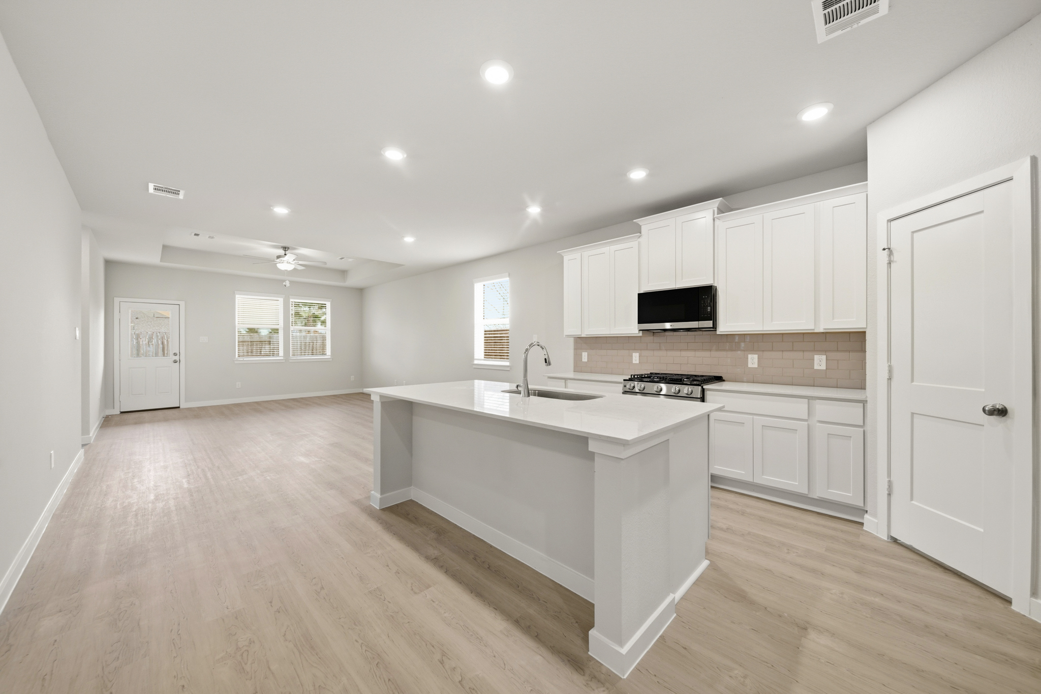 A kitchen with white cabinets.