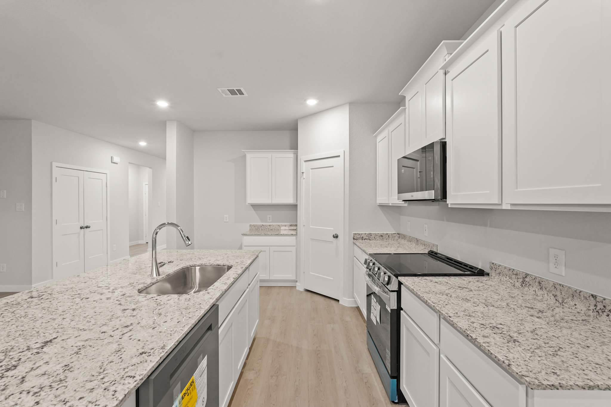 A kitchen with white cabinets.