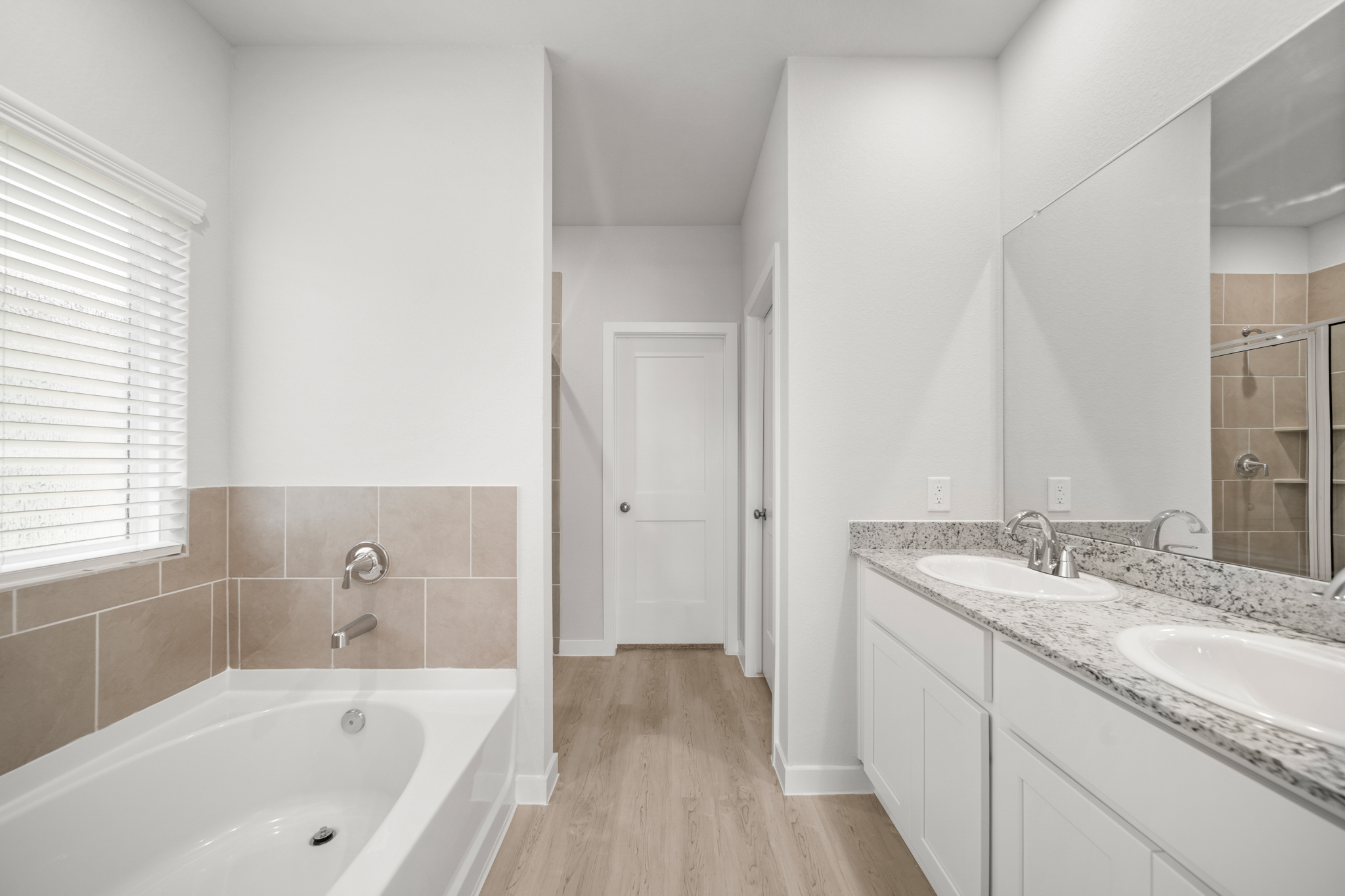 A bathroom with a tub sink and a mirror.
