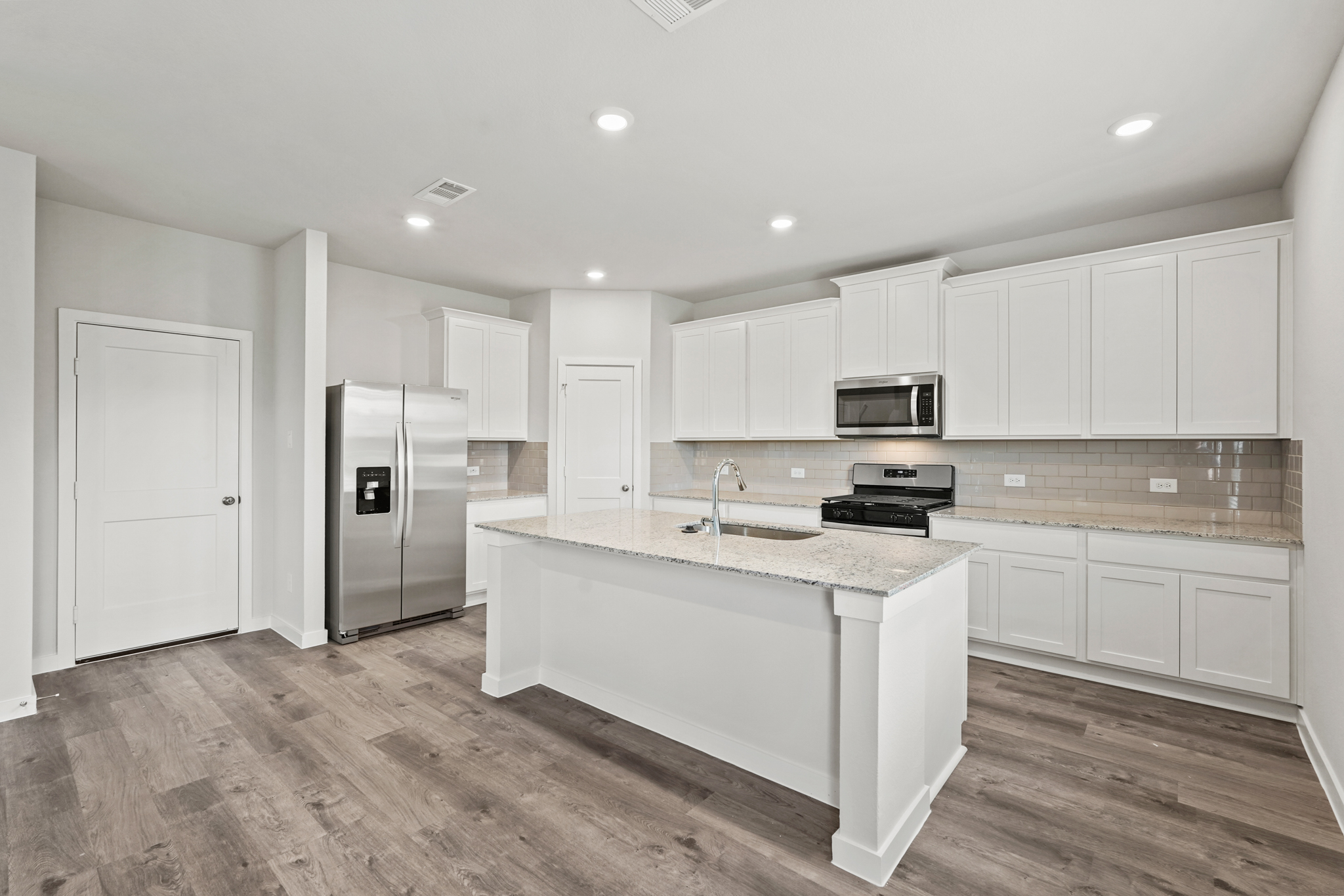 A kitchen with white cabinets.