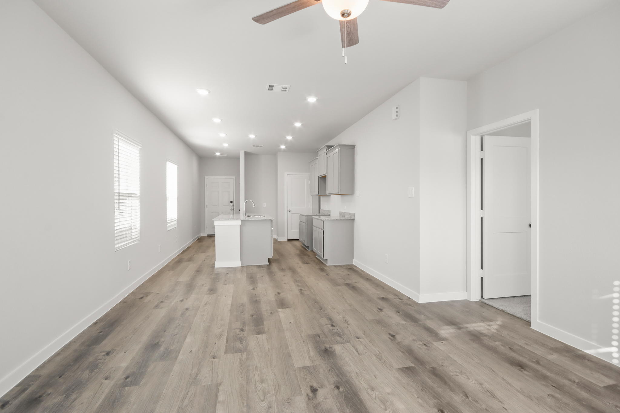 A room with white walls and wood floors.