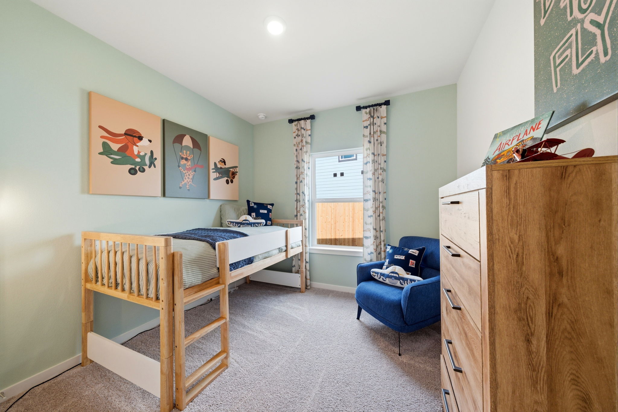 A bedroom with a bed and a chair.