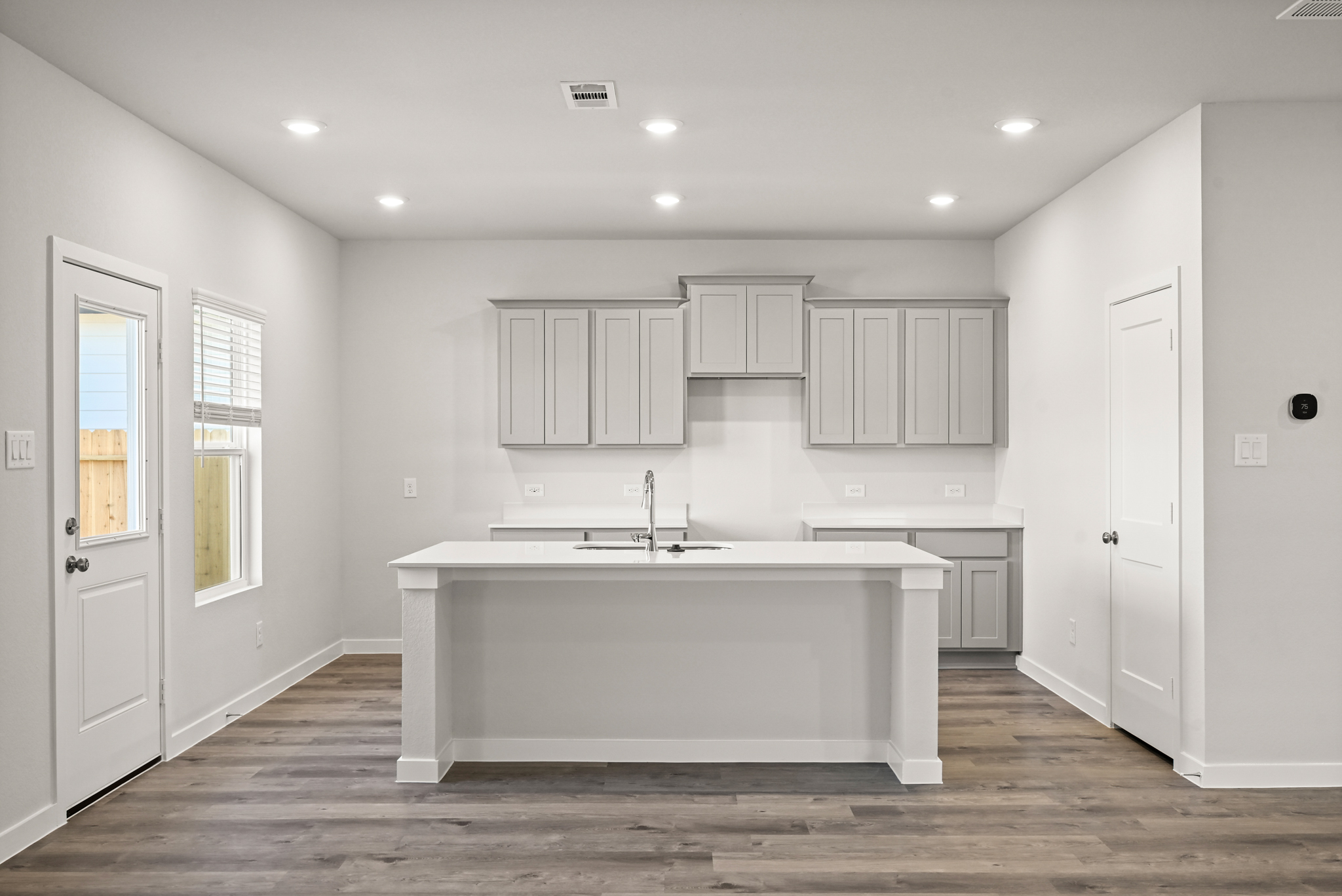 A large white kitchen with white cabinets.