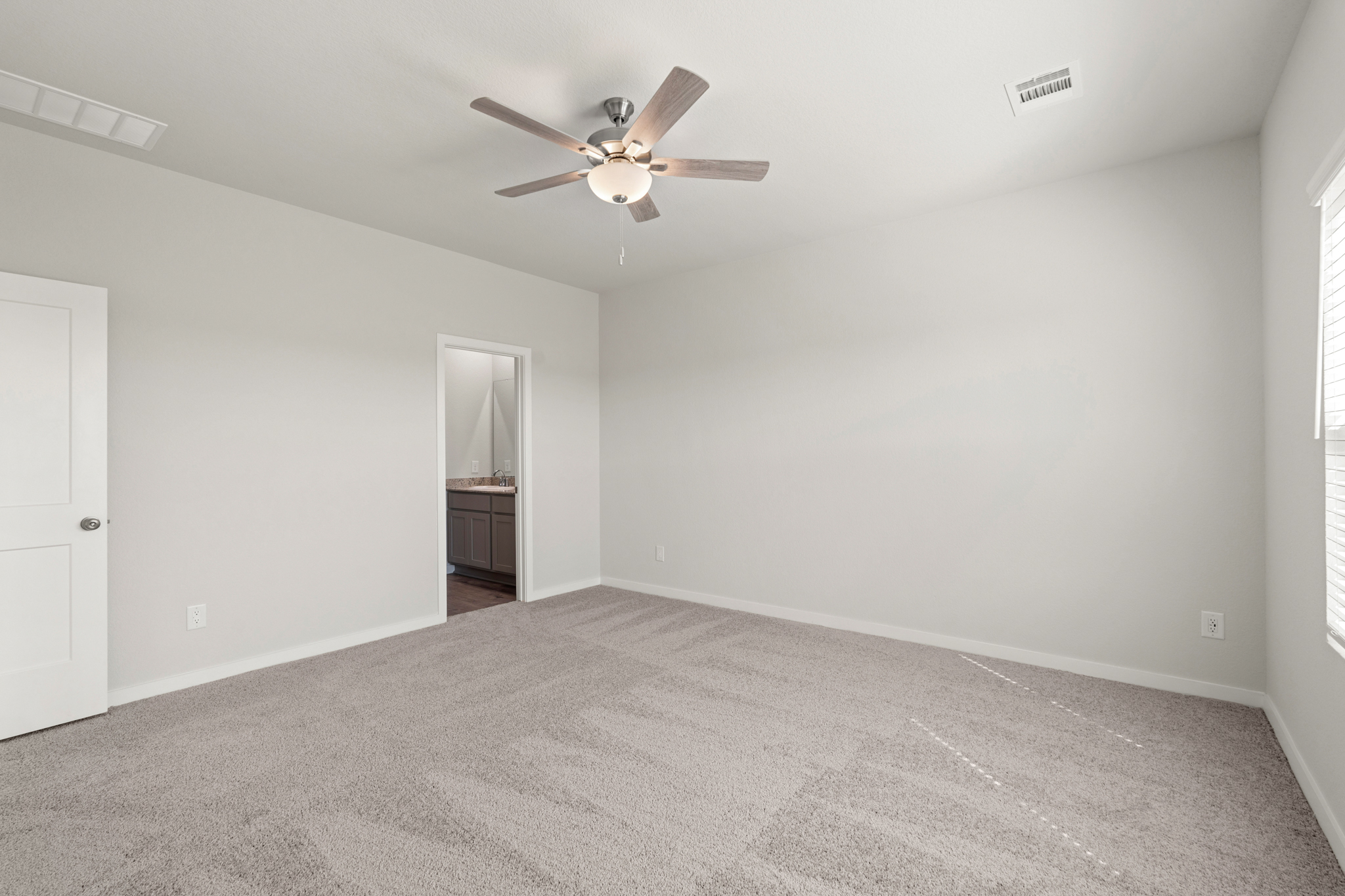 A room with a ceiling fan and a door.