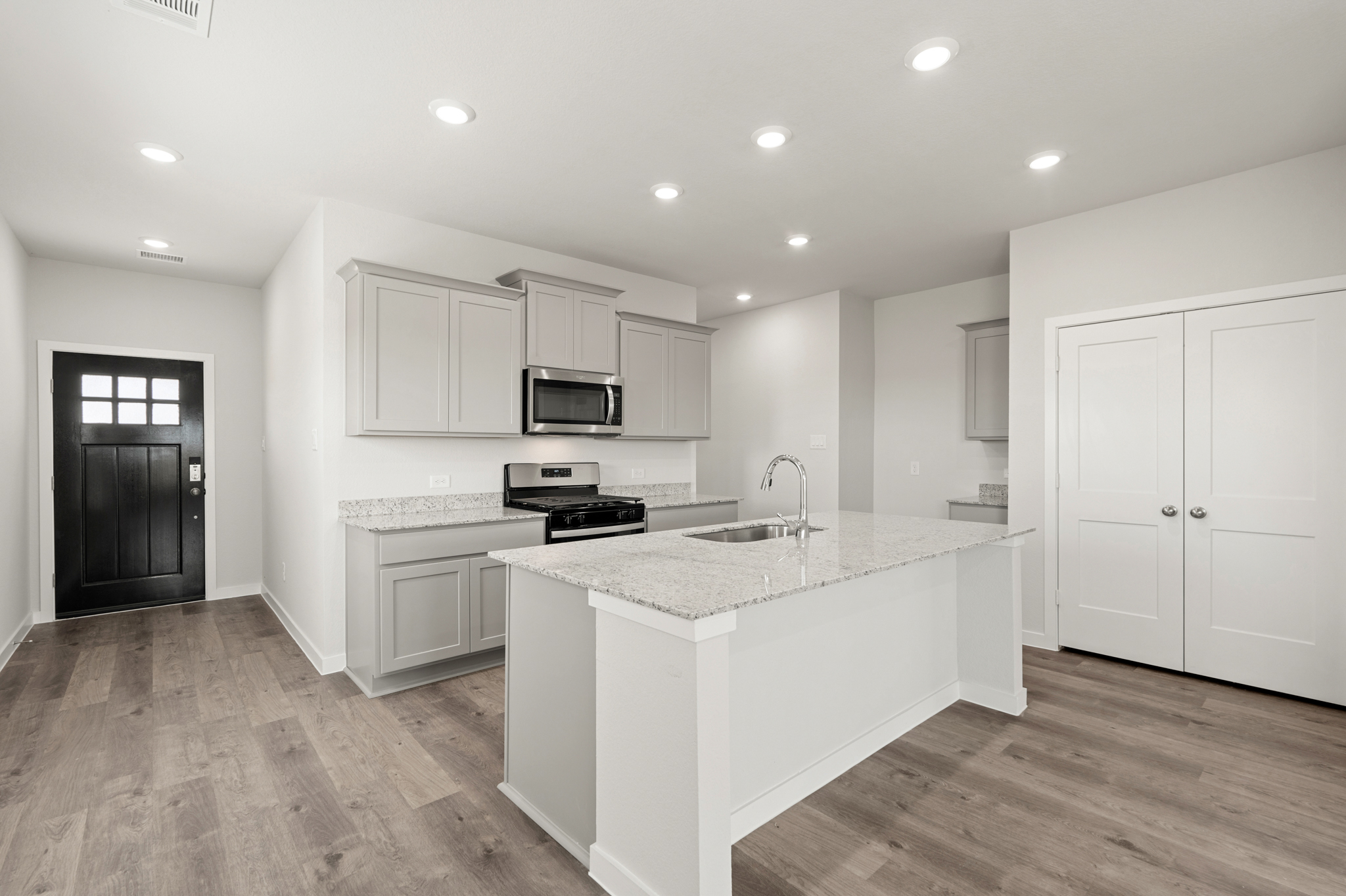 A kitchen with white cabinets.