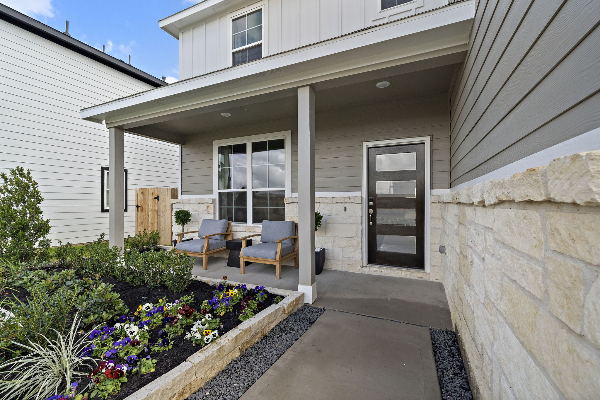 A patio with chairs and a table outside of a house.