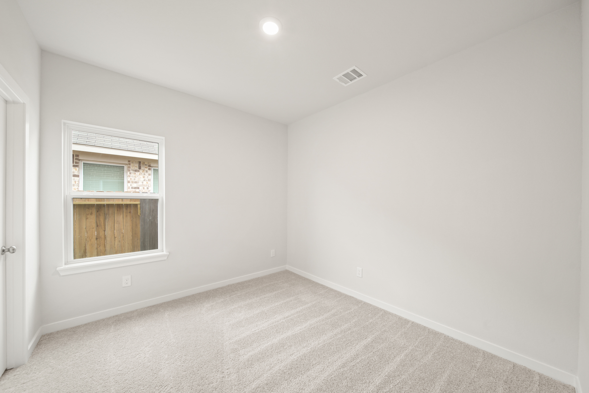 A room with a window and a carpet.