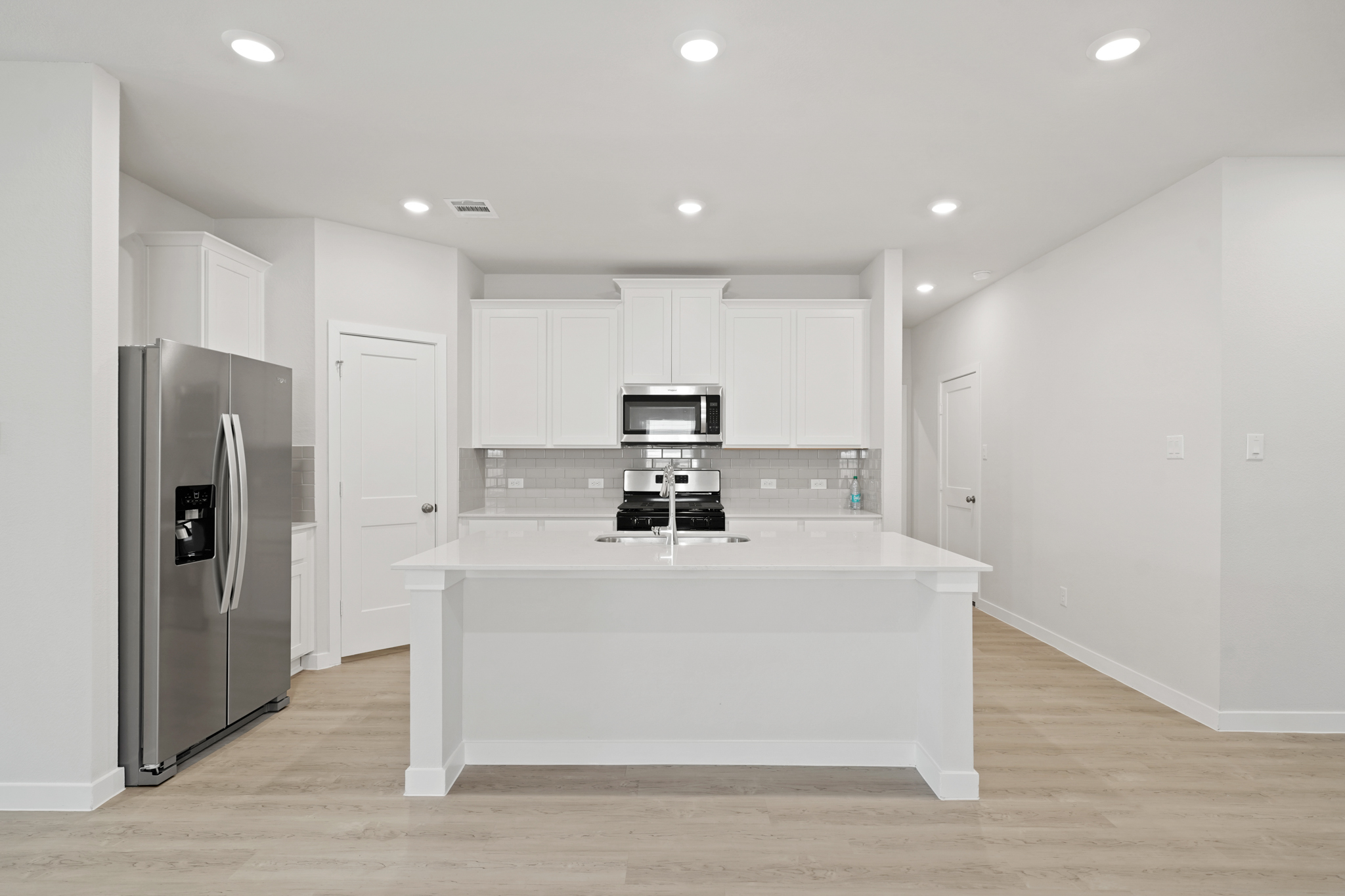 A kitchen with white cabinets.
