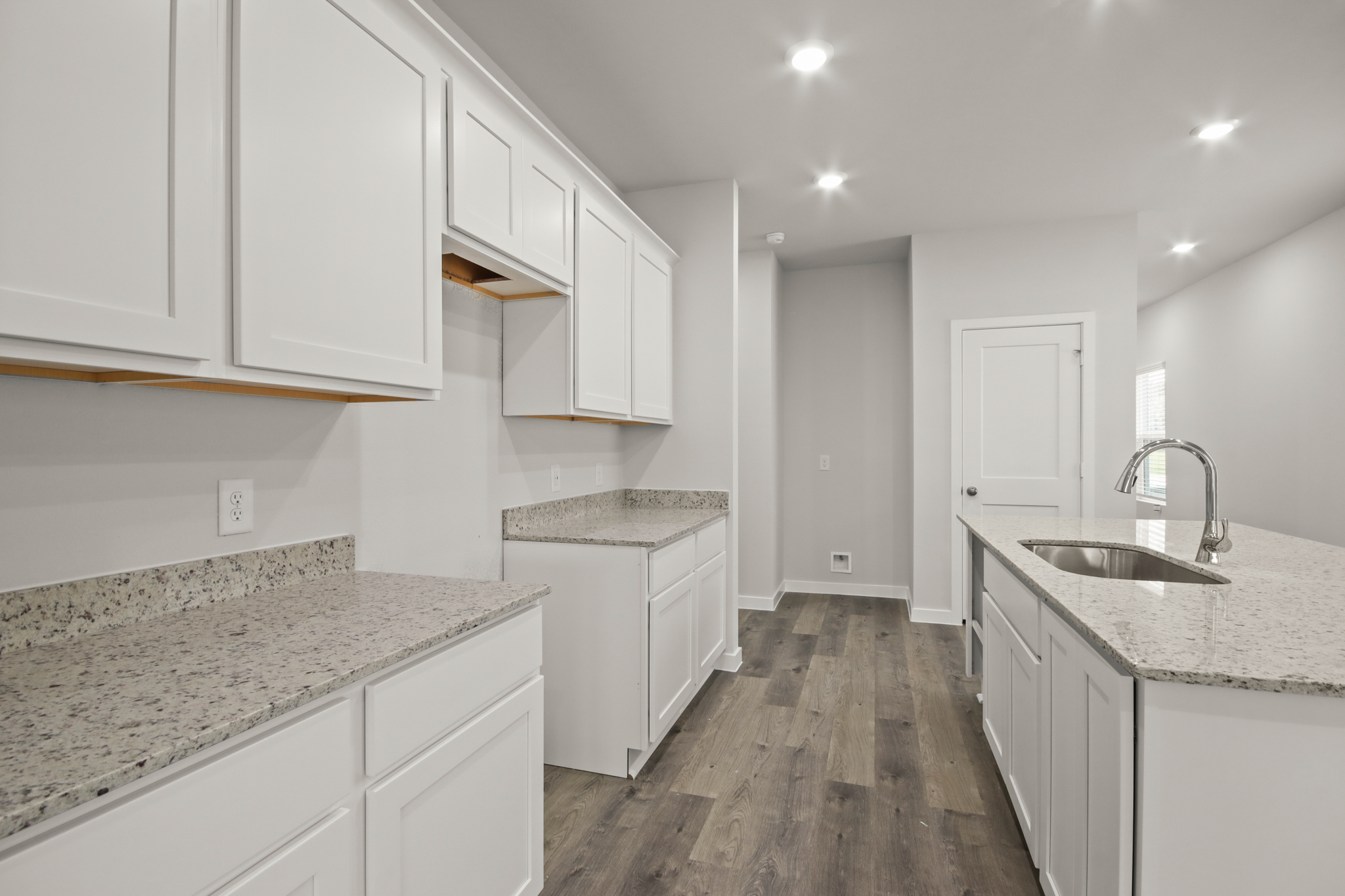 A kitchen with white cabinets.