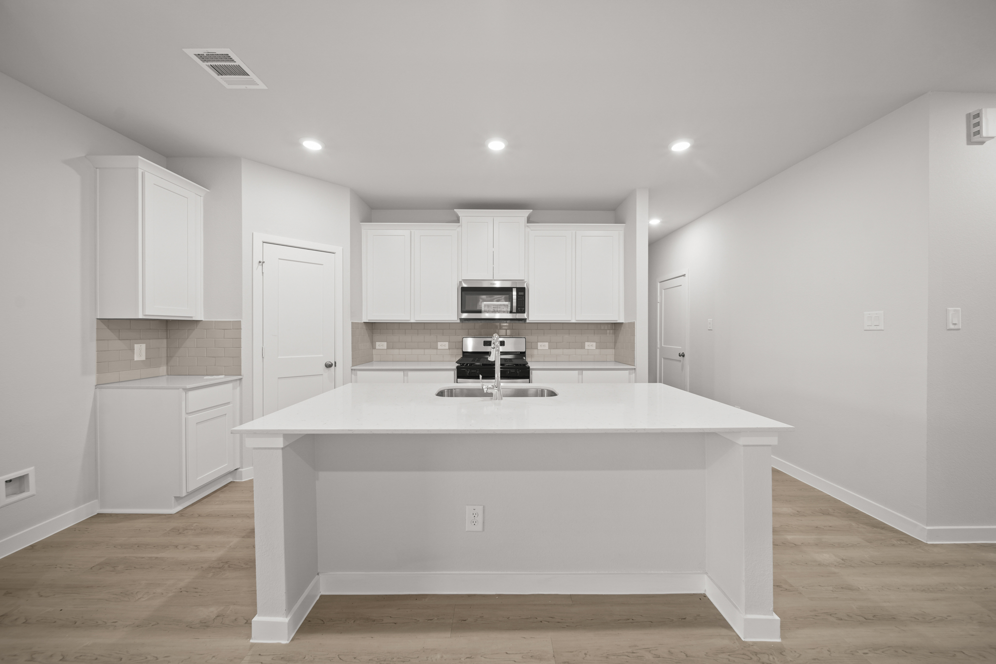 A kitchen with white cabinets.