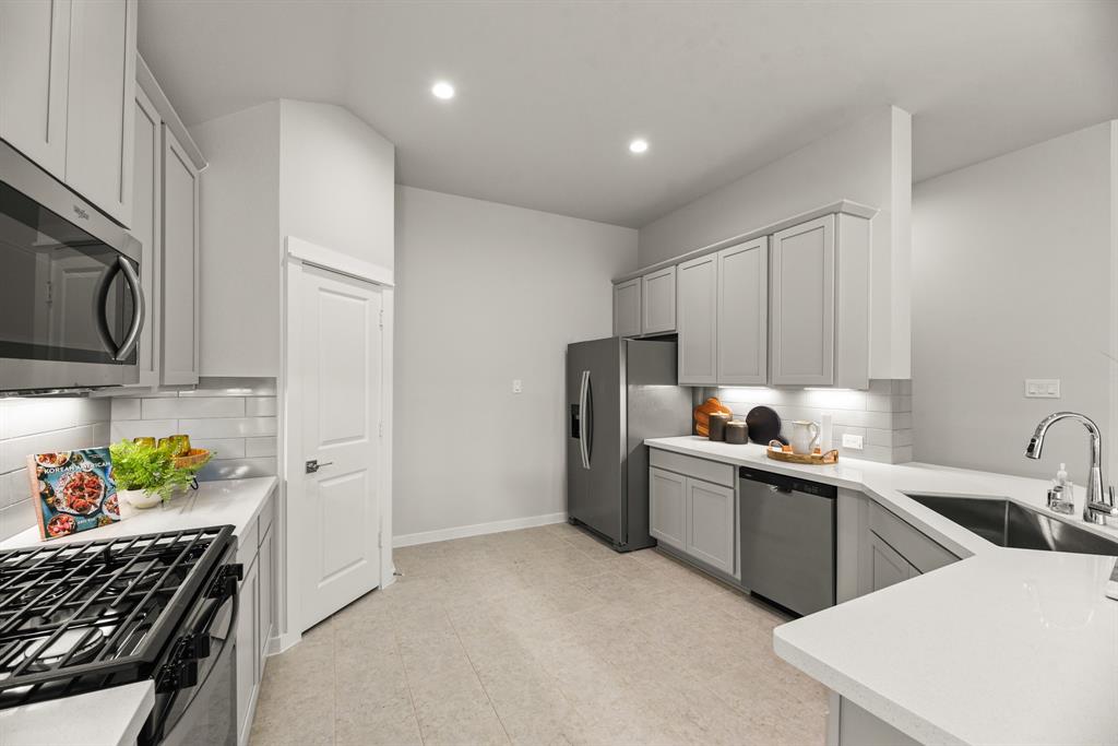 A kitchen with white cabinets.
