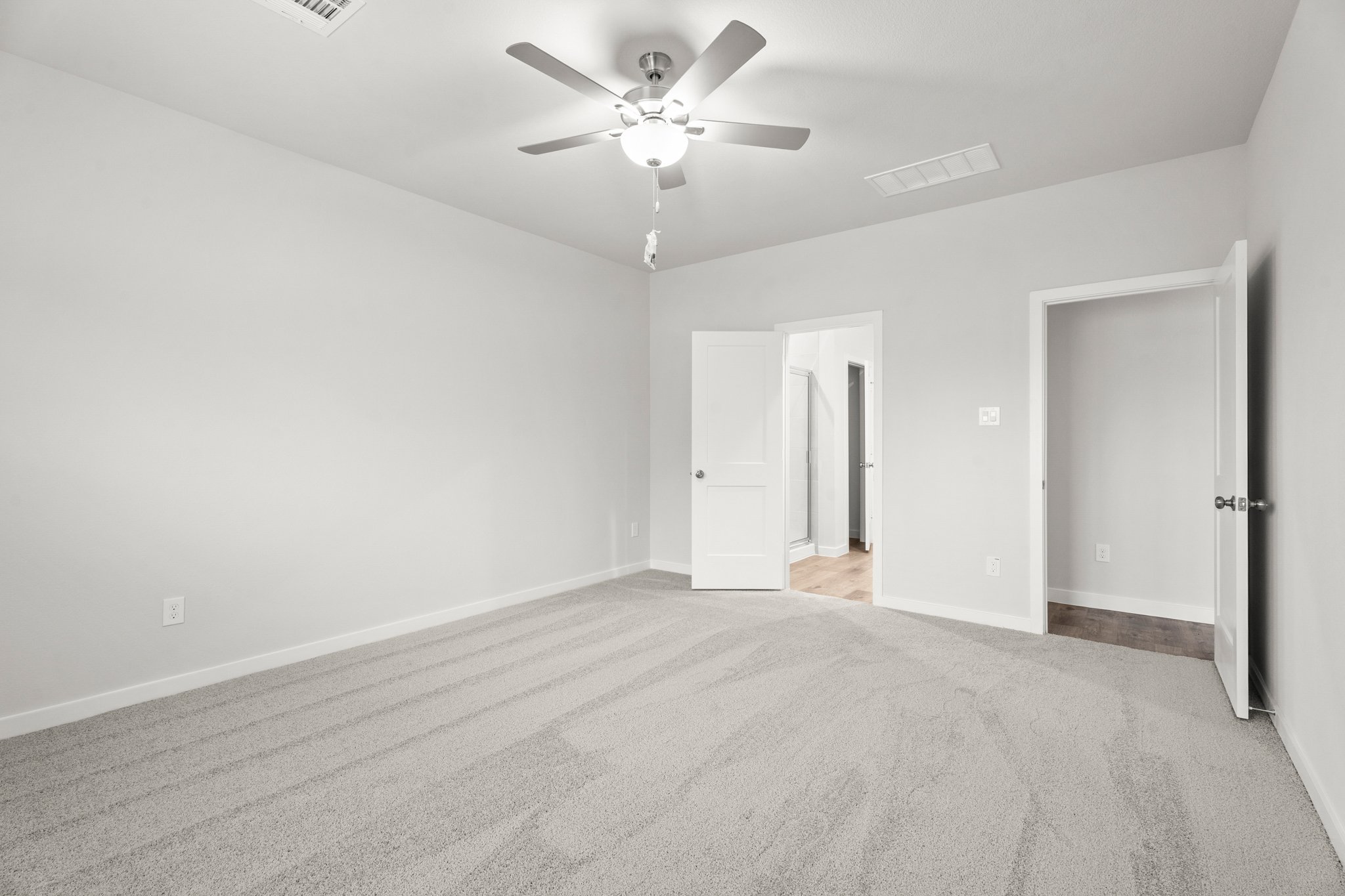 A room with a ceiling fan and a door.