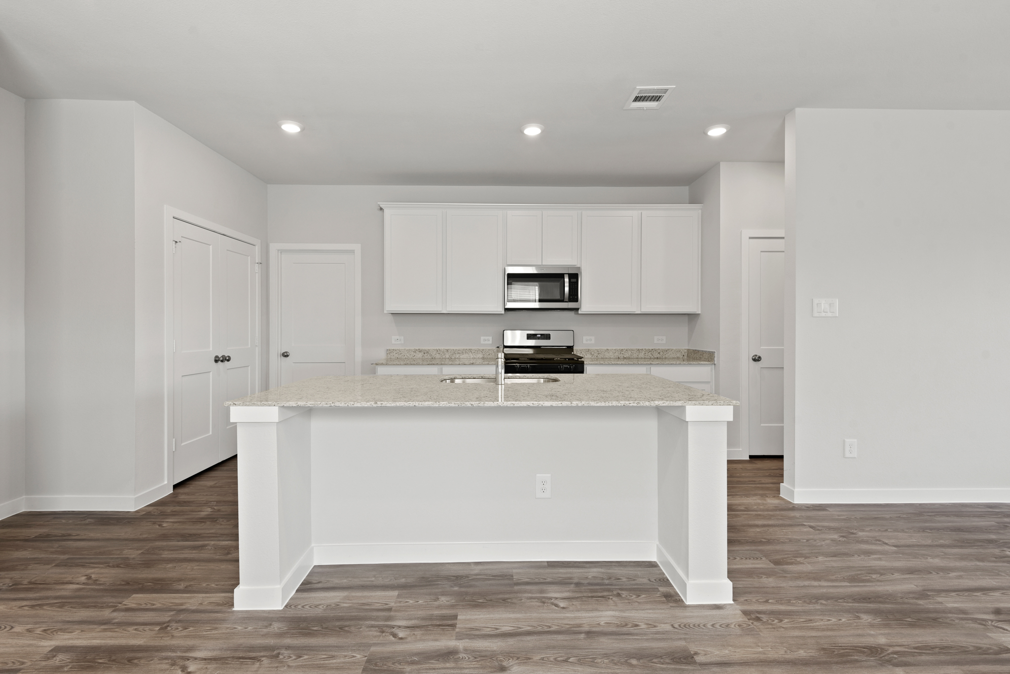 A kitchen with white cabinets.