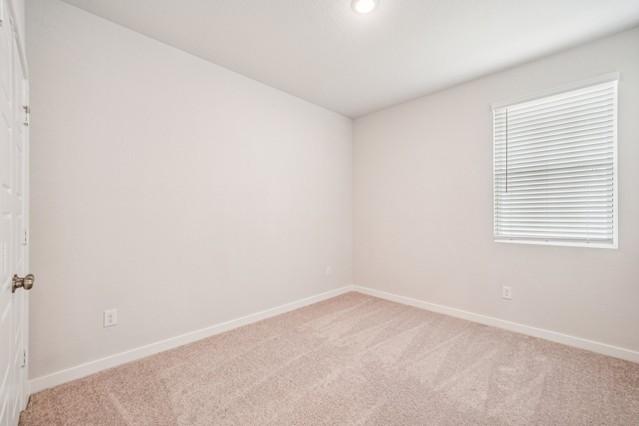 A room with a carpet and a window.