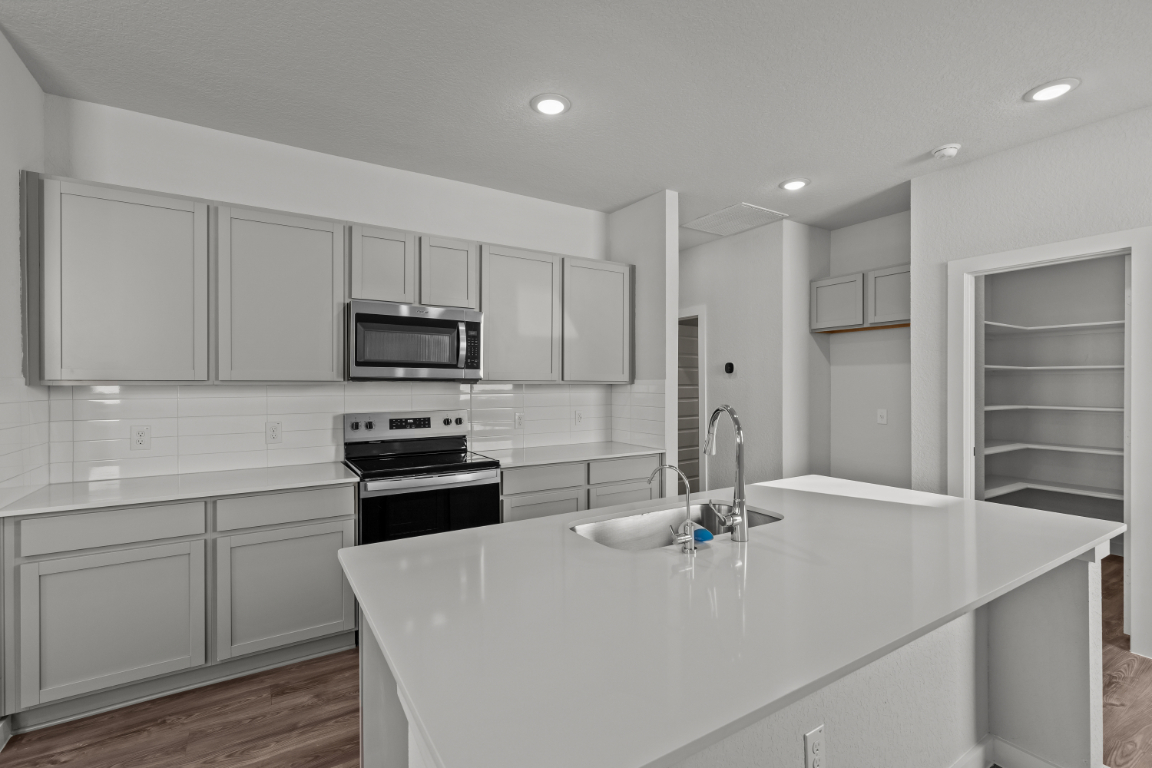 A kitchen with white cabinets.
