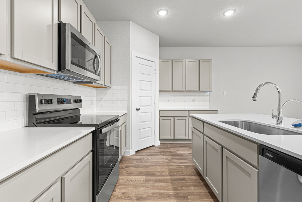 A kitchen with white cabinets.
