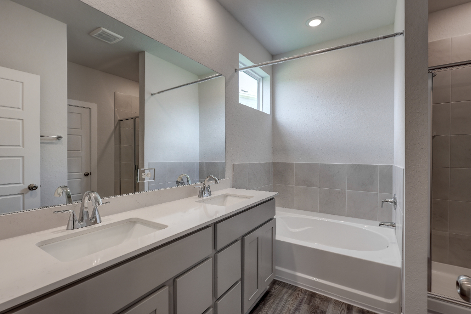 A bathroom with a tub sink and mirror.