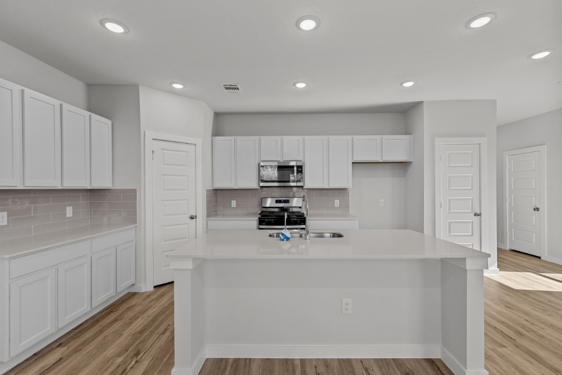 A kitchen with white cabinets.