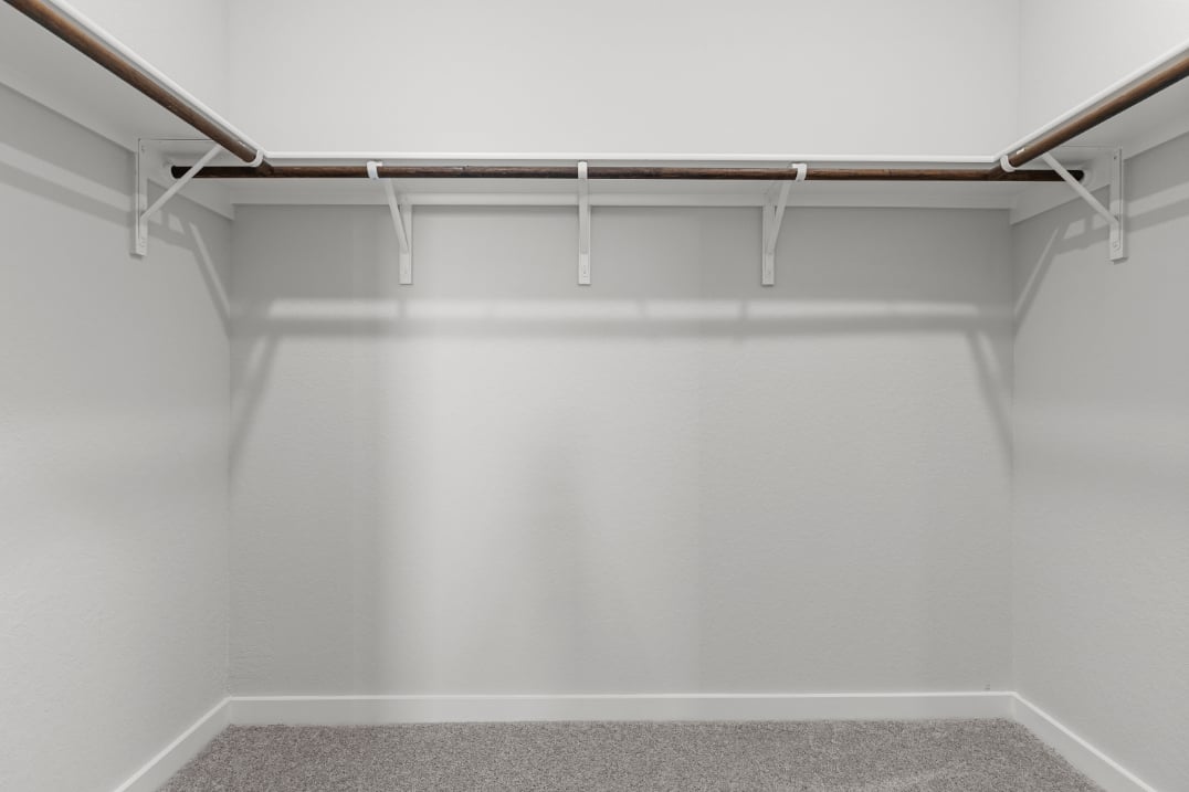 A white wall with a metal bar.
