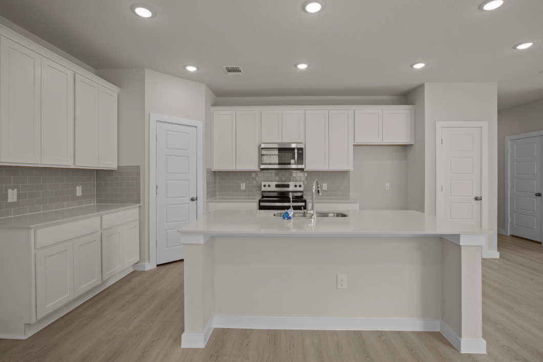 A kitchen with white cabinets.