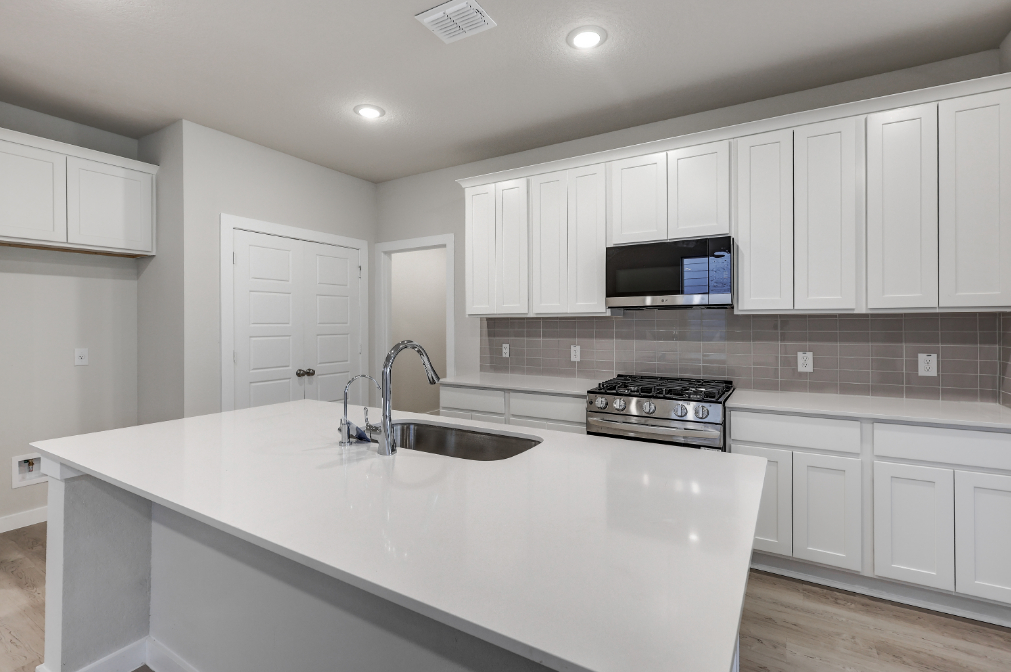 A kitchen with white cabinets.