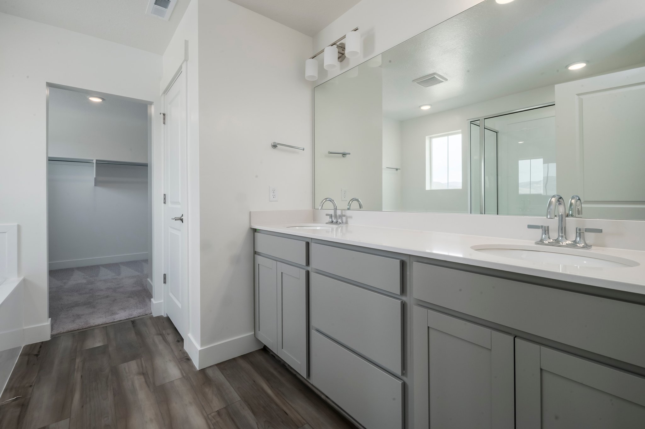 A bathroom with white cabinets.