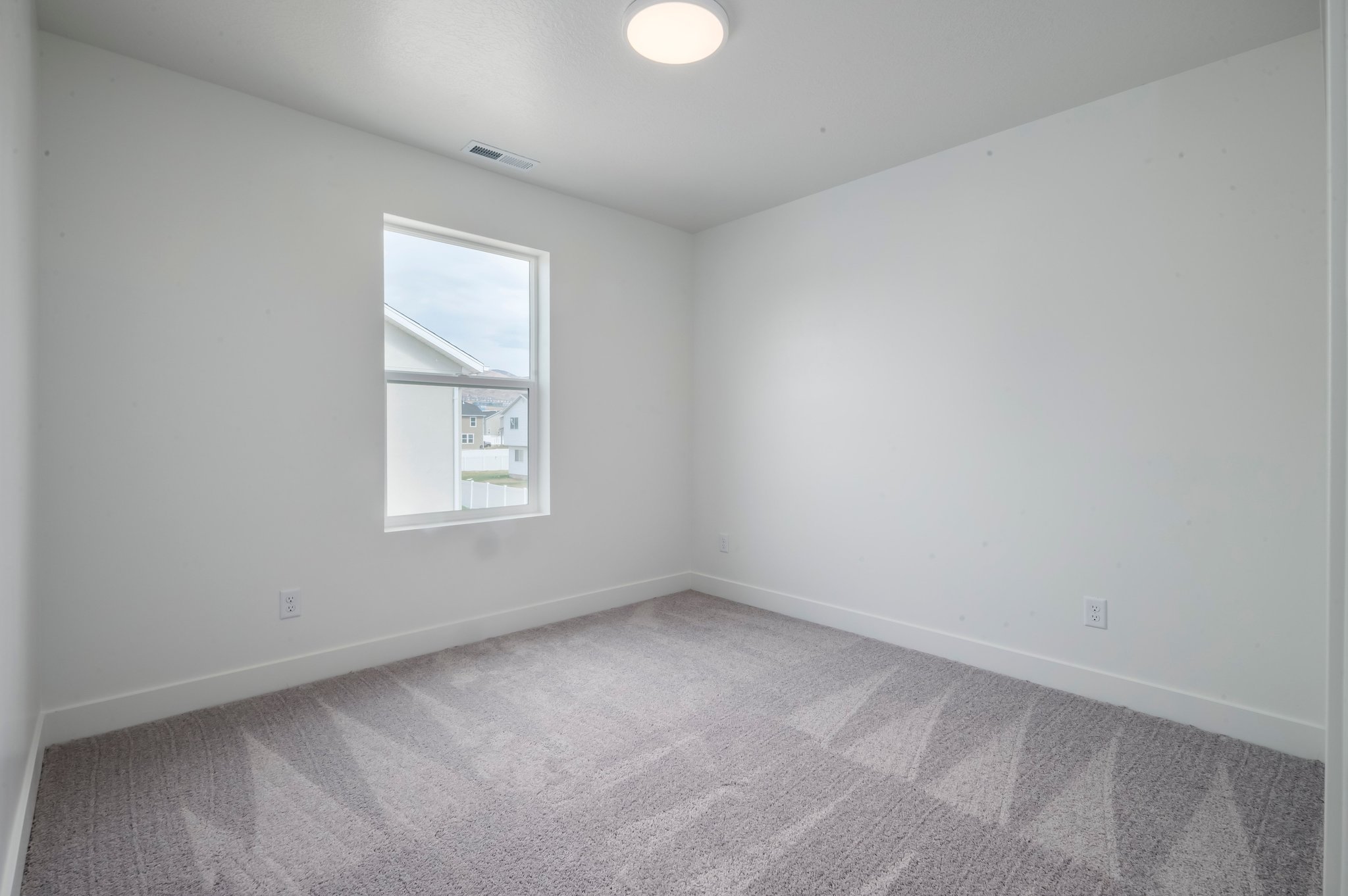 A room with a carpet and a window.