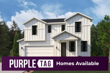 A white house with trees in the back.