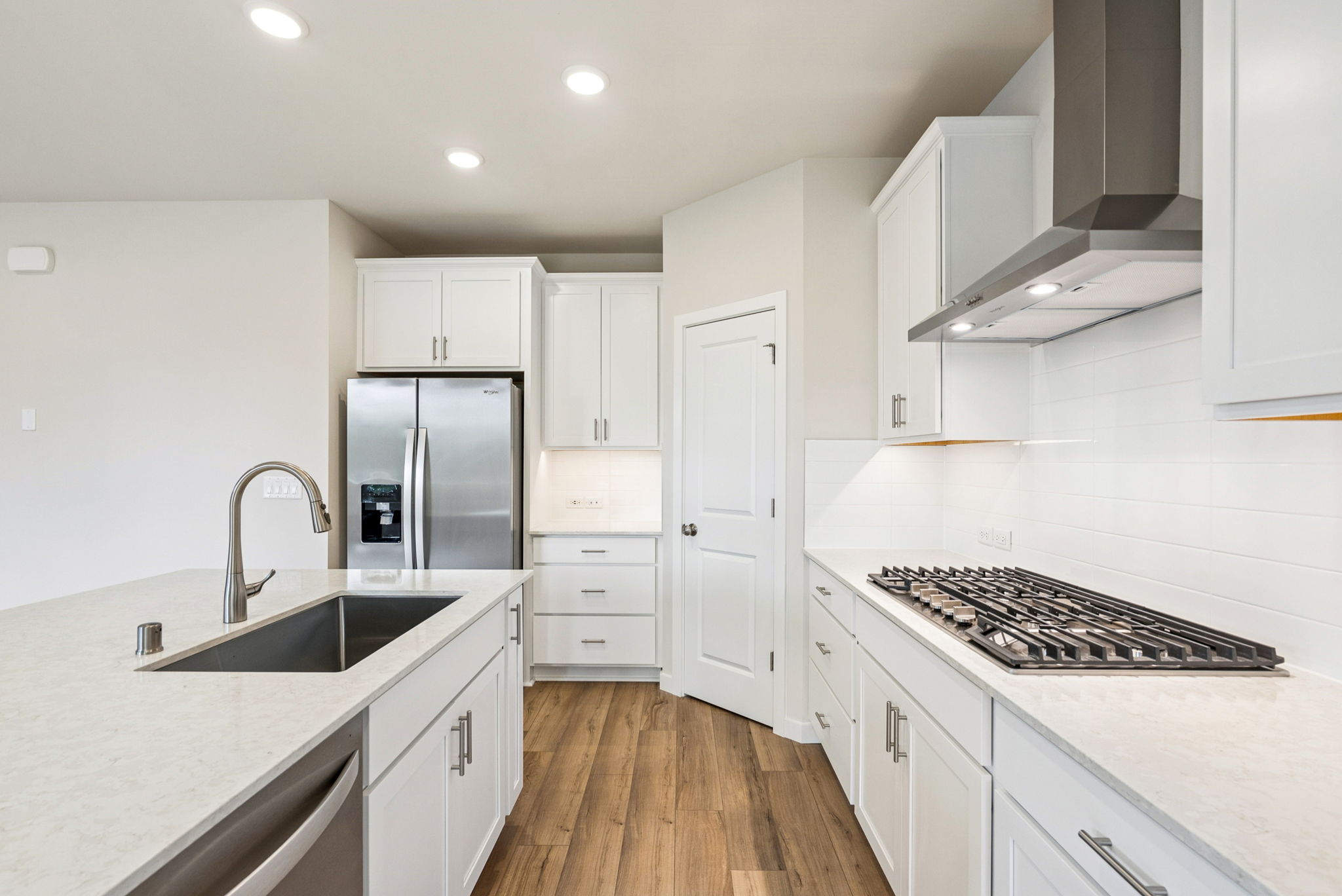 A kitchen with white cabinets.