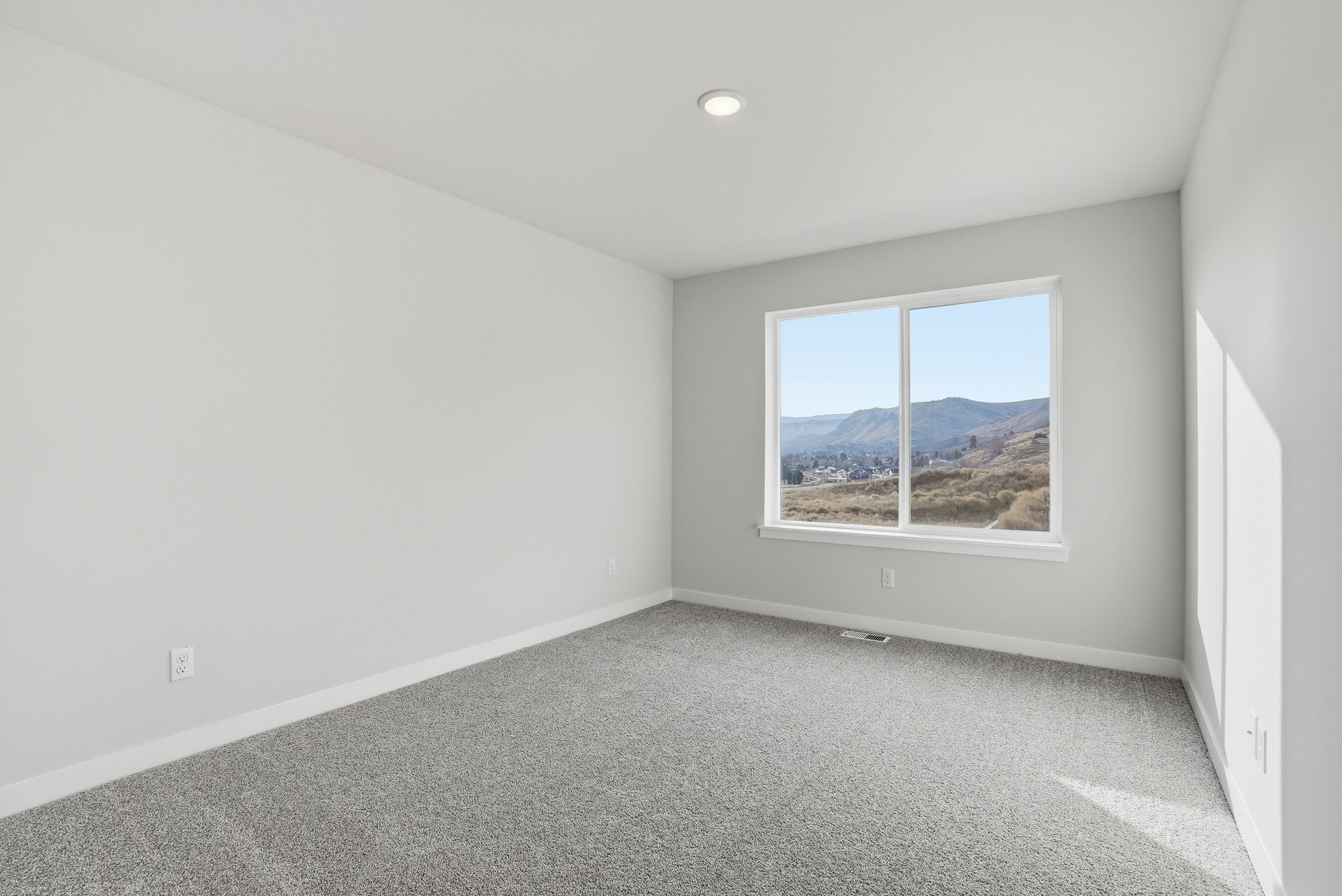 A room with a window and a view of a mountain.