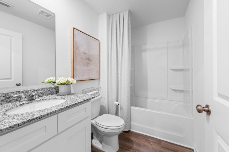 A bathroom with a tub sink and toilet.