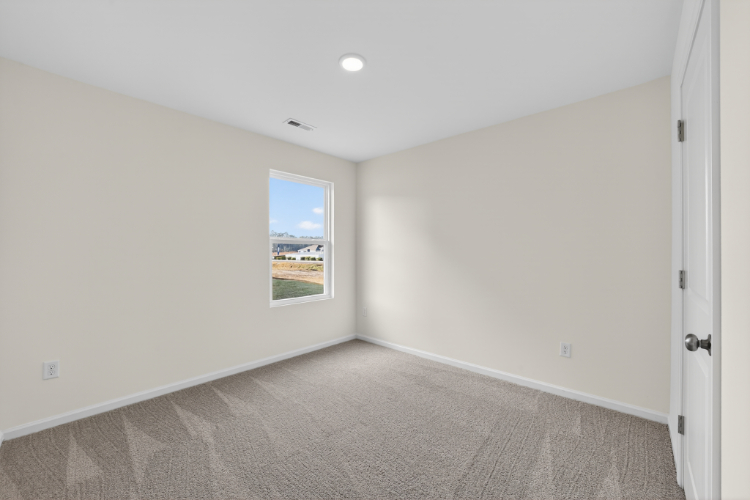 A room with a window and a carpet.