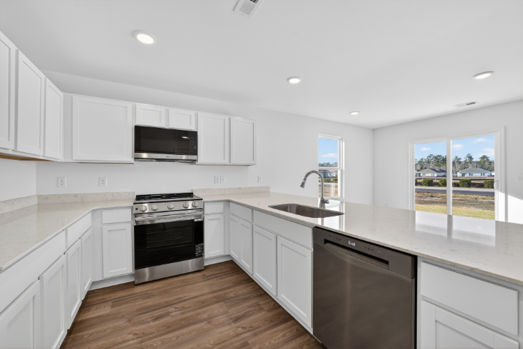 A kitchen with white cabinets.