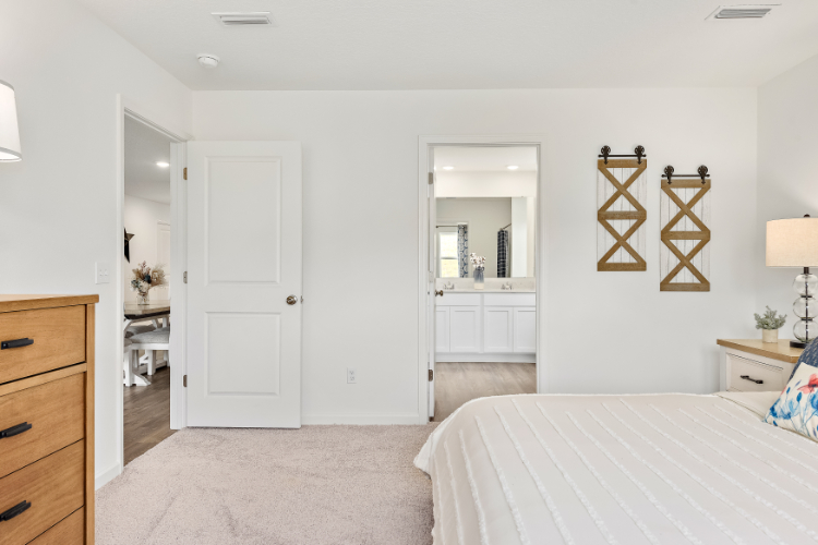 A bedroom with a bed and a mirror.