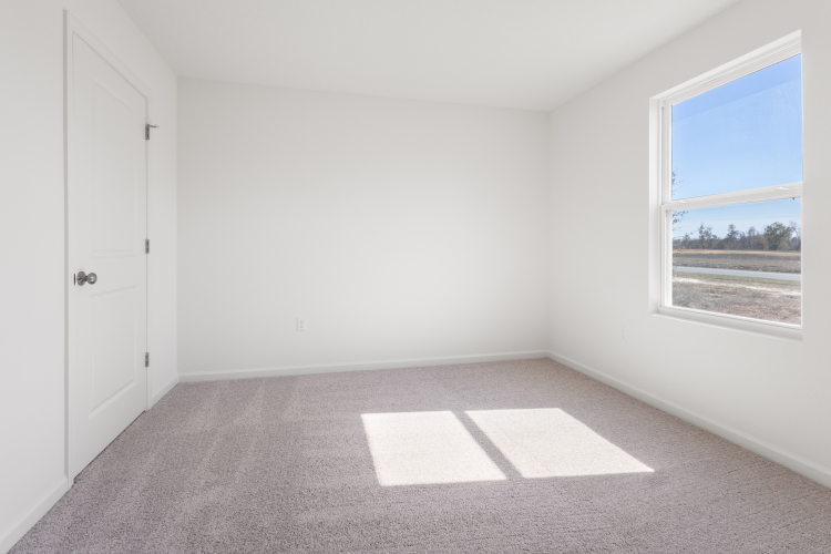 A room with a window and a rug in it.