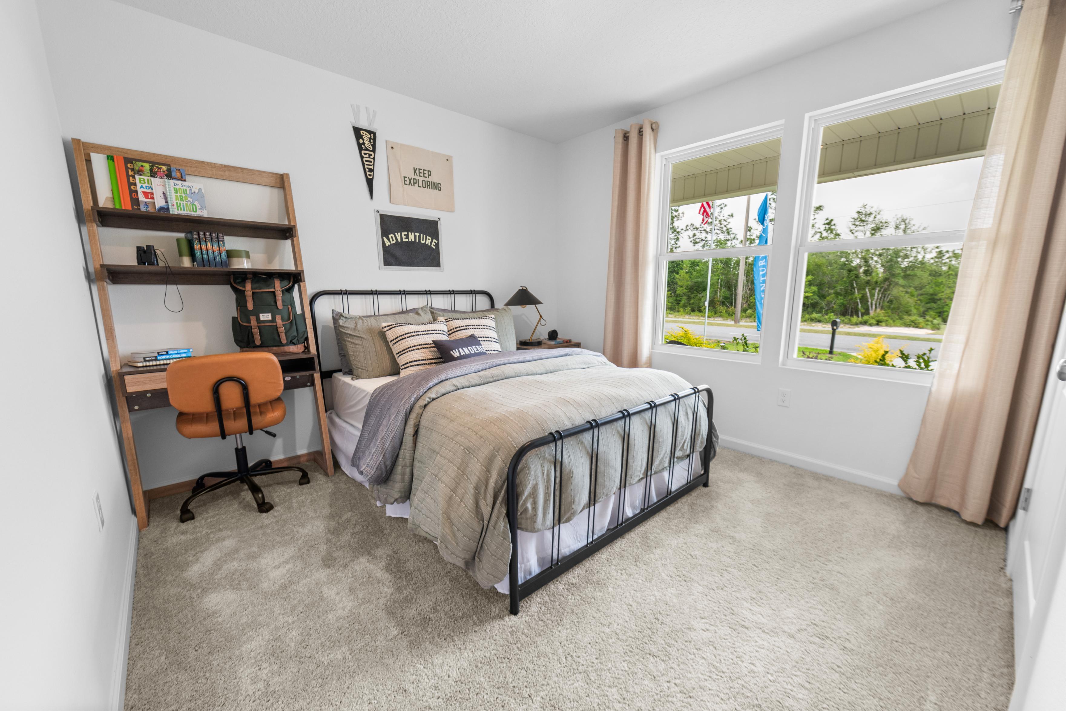 A bedroom with a bed desk and bookshelf.